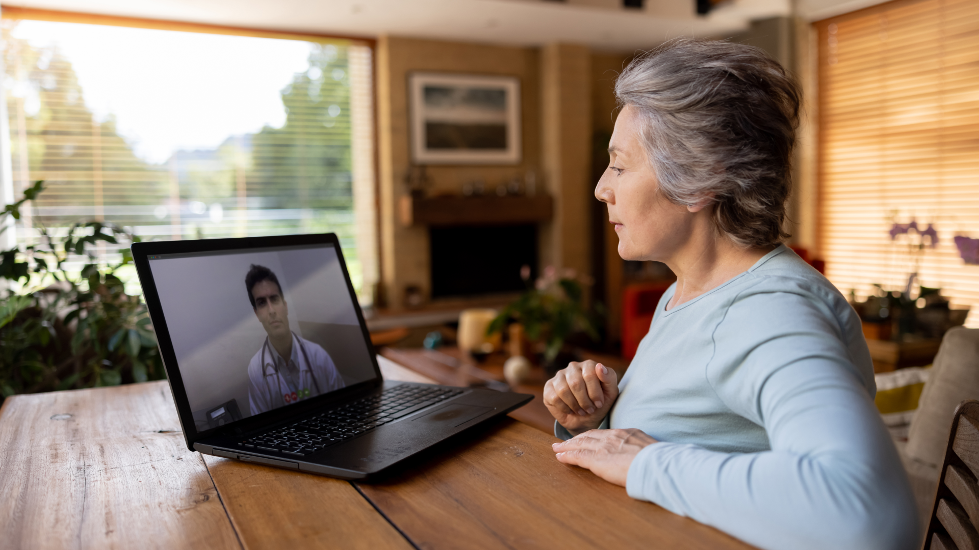 A older person on their laptop in a telehealth call with their healthcare provider